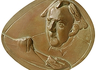 Eine ovale, bronzefarbene Medaille, die ein Porträt von Hans van der Grinten im Hochrelief zeigt