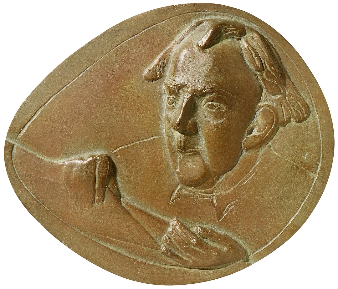 Eine ovale, bronzefarbene Medaille, die ein Porträt von Hans van der Grinten im Hochrelief zeigt