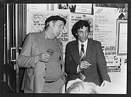 Das Schwarzweiß-Foto zeigt zwei Personen, links Hans van der Grinten, rechts Jan Hoet, bei einem Vortrag von Joseph Beuys in Nimwegen